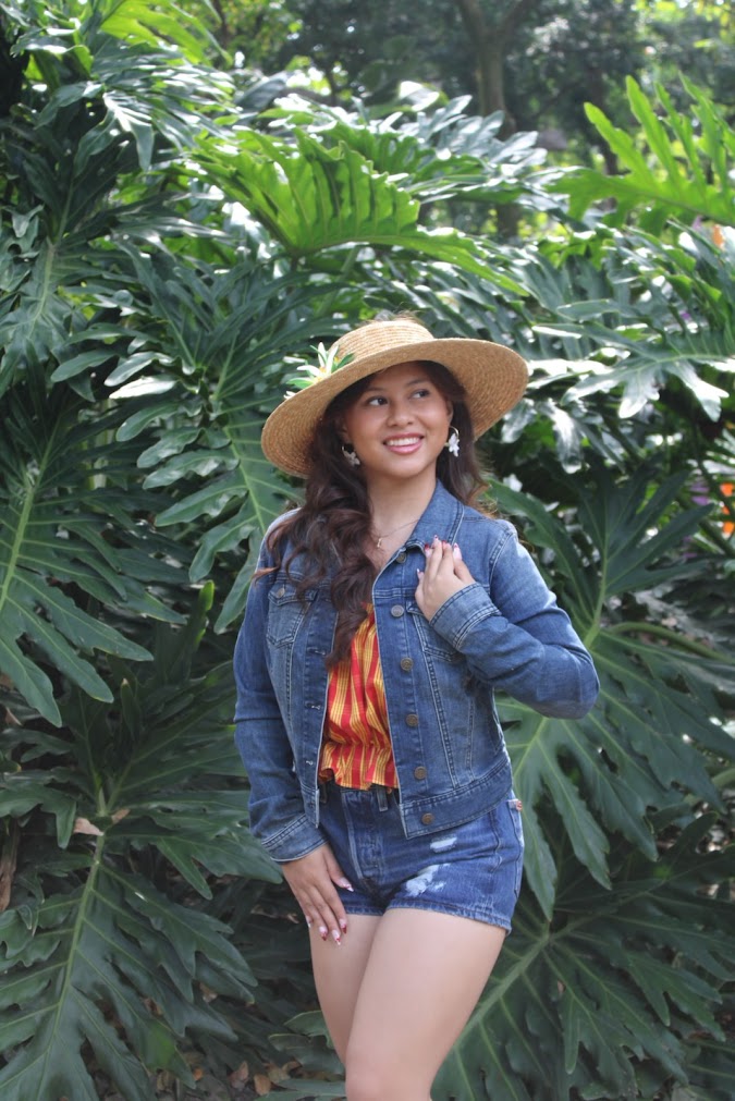 Model wearing hand-painted Hawaiian print design denim jacket and shorts, Palaka print top and handmade Pikake clay hoop earrings, crafted in Hawai‘i by Culture Girl Boutique