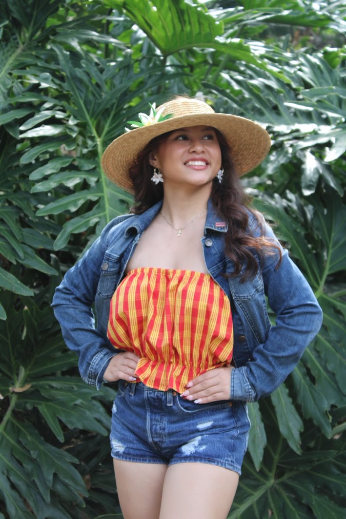 Model wearing hand-painted Hawaiian denim jacket and shorts with Palaka top and handmade Pikake hoop earrings by Culture Girl Boutique