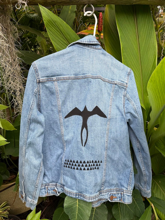 Hand-painted Iwa Bird and Lokahi Triangle on a light wash denim jacket
