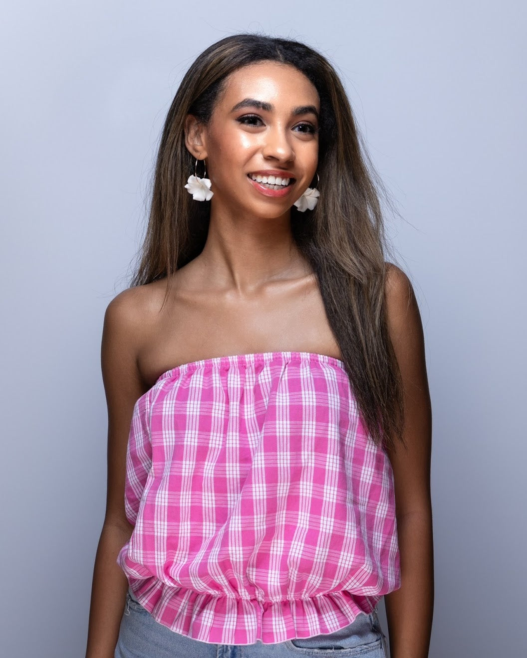 Model wearing pink colored Palaka print top and handmade Pikake clay hoop earring, crafted in Hawai‘i by Culture Girl Boutique